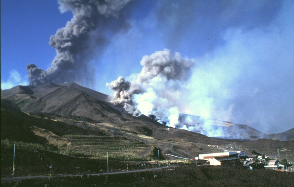 Etna during the climax of the 2001 eruption, which took place on 21-23 July. The upper ash column rises from a vent on the far side of Montagnola. The lower, smaller series of plumes rise from vents and associated lava flow at 2,100 m elevation. The 2001 eruption began on 17 July and lasted until 9 August.  Photo by Jean-Claude Tanguy, 2001 (University of Paris).
