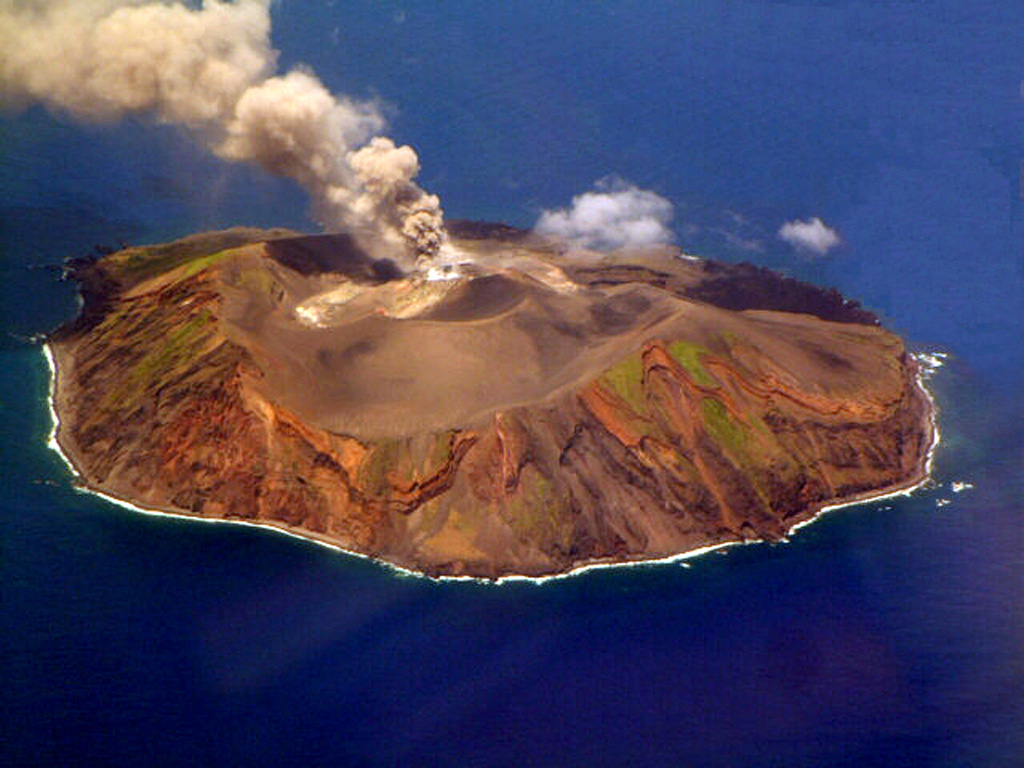 This photo taken on 12 August 2002 shows an ash plume rising from Torishima volcano, a 2.7-km-wide island in the southern Izu Islands. The unvegetated Iwoyama cone, seen here from the south, was constructed during an eruption in 1939 within a 1.5-km-wide caldera. The volcano is also referred to as Izu-Torishima to distinguish it from the several other Japanese island volcanoes called Torishima ("Bird Island"). Photo courtesy of Japan Meteorological Agency, 2002.