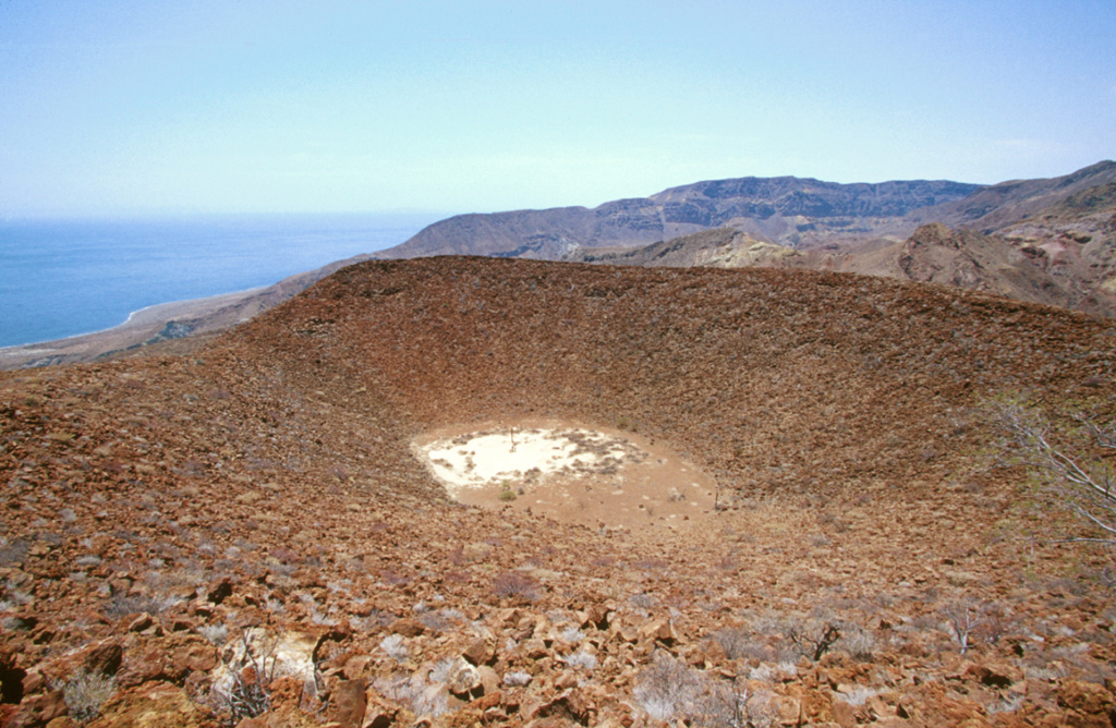 The summit crater of La Vírgen parasitic cinder cone on the east flank of La Reforma caldera is seen from its north rim.  The SE rim of 10-km-wide La Reforma caldera forms the ridge on the horizon with the Gulf of California on the left.   Photo by Keith Sutter, 2000.