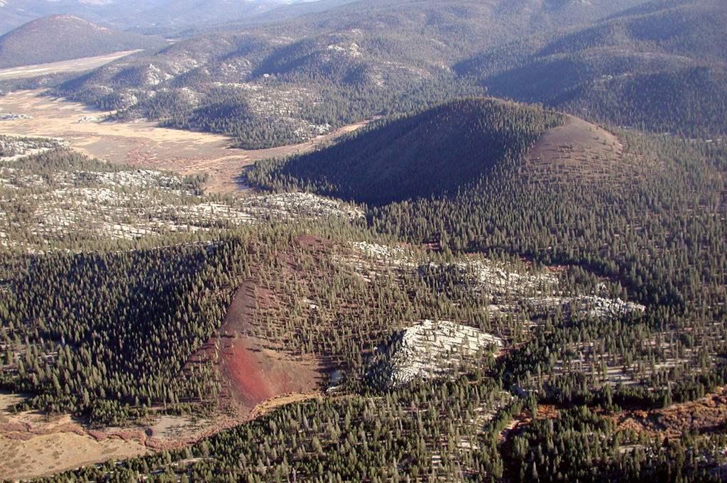 Tunnel cinder cone (lower left) and South Fork cone (upper right) are seen from the NW with Ramshaw Meadow at the upper left.  The South Fork cone was erupted about 176,000 years ago and produced the largest lava flow of the volcanic field, which traveled 10 km to the west, possibly as far as the floor of Kern Canyon.  Tunnel cone to the north of South Fork (Red Hill) cone is undated, but its lava flow is overlain by glacial deposits and it is thought to be only slightly younger than South Fork cone. Photo by Rick Howard, 2002 (courtesy of Del Hubbs, U S Forest Service).