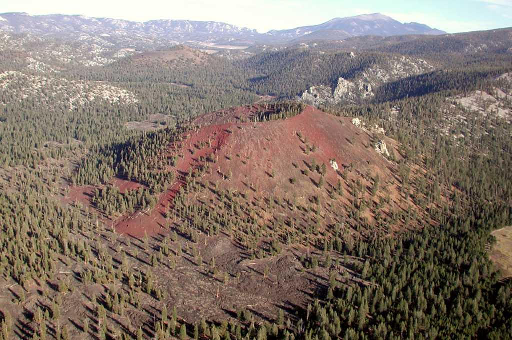 Groundhog cinder cone is the youngest of the Golden Trout volcanic field.  It is seen here from the west with South Fork cone behind it at the upper left and Olancha Peak on the crest of the Sierra Nevada on the right horizon.  Groundhog cone is breached to the NE and was the source of large lava flows (visible in the foreground) that traveled 6 km to the west.  The flows filled the valley of Golden Trout Creek and displaced it to the north side, separating Golden Trout Creek from Volcano Creek at the southern margin of the flow.  Photo by Rick Howard, 2002 (courtesy of Del Hubbs, U S Forest Service).