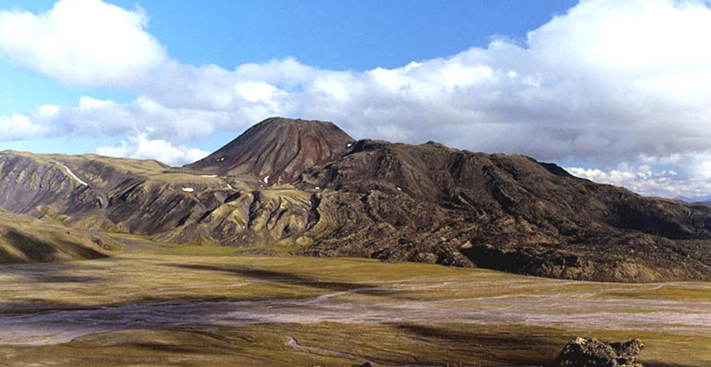 The Yuzhny Cherpuk cinder cone (left-center horizon) and its andesitic lava flow are located 11 km SSW from Ichinsky volcano. The fresh-looking lava flow was erupted about 6,500 years ago and traveled 18 km. Severny Cherpuk (South Cherpuk) and Yuzhny Cherpuk (North Cherpuk) are two cinder cones SW of Ichinsky that comprise the largest monogenetic volcanoes of the Sredinny Range. Severny Cherpuk, 21 km SW of Ichinsky, is a double cone that was constructed along the crest of the Sredinny Range. Copyrighted photo by Adam Kirilenko, 2000 (Holocene Kamchatka Volcanoes, www.kamchatka.ginras.ru).