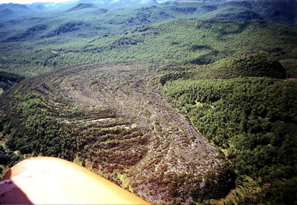 Flow ridges are visible on the surface of a sparsely vegetated lava flow originating from the Veer scoria cone to the right, in the Levaya Avacha river valley. Veer is one of a number of cones scattered throughout the Avacha river basin. This eruption took place 1,600-1,700 years Before Present (BP). Copyrighted photo by Oleg Dirksen (Holocene Kamchataka volcanoes; http://www.kscnet.ru/ivs/volcanoes/holocene/main/main.htm).