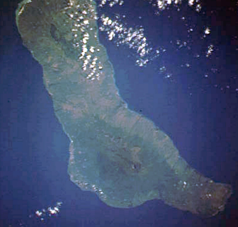 Grand Comore Island in the Indian Ocean NW of Madagascar is formed by two massive shield volcanoes. The more well-known and historically active Karthala volcano at the southern end of the island has a 3 x 4 km summit caldera. Elongated rift zones extend to the NNW and SE; the lower SE rift zone forms the Massif du Badjini, a peninsula at the SE tip of the island (bottom right). The Holocene La Grille volcano forms the northern part of the island. Youthful lava flows from both volcanoes have reached the coast. NASA Space Shuttle image STS009-39-2516, 1983 (http://eol.jsc.nasa.gov/).