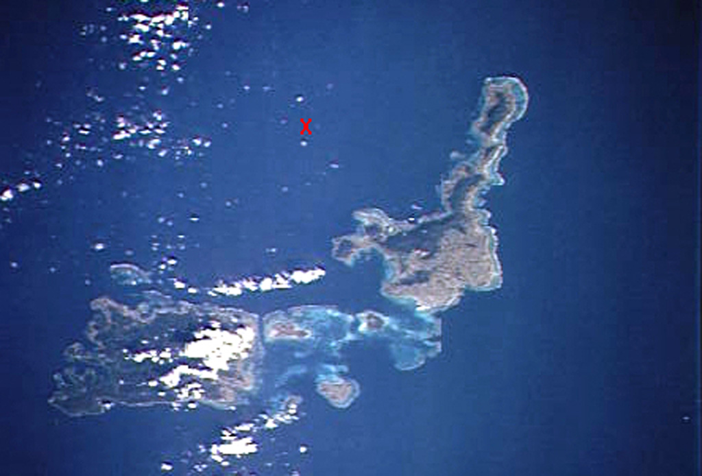 An "X" marks the approximate location of Iriomote-jima submarine volcano, the southernmost Ryukyu Islands volcano.  The submarine volcano is located north of the NE tip of 30-km-wide Iriomote-jima island (lower left) and WSW of the northern tip of the island of Ishigaki-shima (right-center).  A major submarine eruption that was volumetrically one of the largest in Japan during historical time took place at this volcano on October 31, 1924.  It produced pumice rafts that were carried by currents along both coasts of Japan as far north as Hokkaido.  NASA Space Shuttle image STS66-117-19, 1994 (http://eol.jsc.nasa.gov/).
