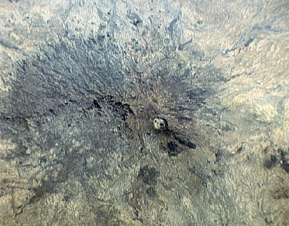 The small circular area just right of the center of this Space Shuttle image is Deriba caldera, the most prominent feature of the vast Jebel Marra volcanic field in western Sudan. The 5-km-wide, steep-walled caldera was formed about 3,500 years ago during an eruption that produced voluminous airfall pumice and pyroclastic flows that traveled more than 30 km from the volcano. Ash eruptions may have continued into early historical time, and fumarolic activity continues on the flanks of the caldera. NASA Space Shuttle image STS32-94-24, 1990 (http://eol.jsc.nasa.gov/).