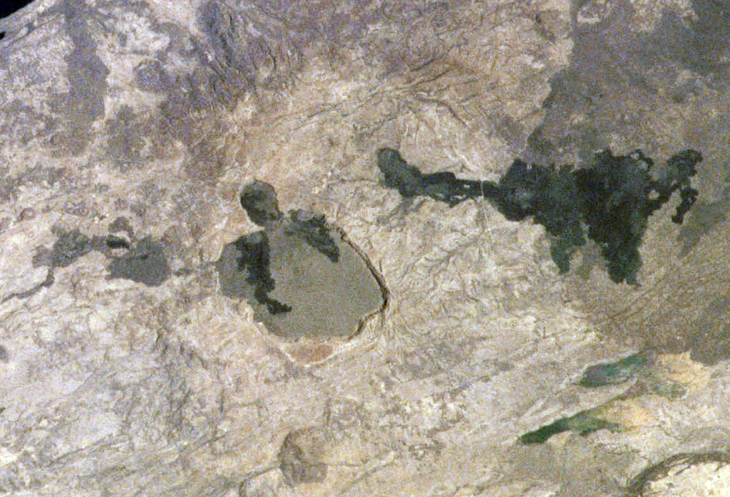 The Kone volcanic complex, also known as Gariboldi, is composed of a series of silicic calderas and young basaltic scoria cones and lava flows. N is towards the lower left in this International Space Station image. The dark-colored basaltic lava flows on the caldera floor were erupted during the first half of the 19th century along a ridge between a smaller caldera to the E and a larger 5-km-wide caldera to the W. The larger young lava flow at the right was erupted from a vent on the SE flank. NASA International Space Station image ISS001-363-9, 2001 (http://eol.jsc.nasa.gov/).