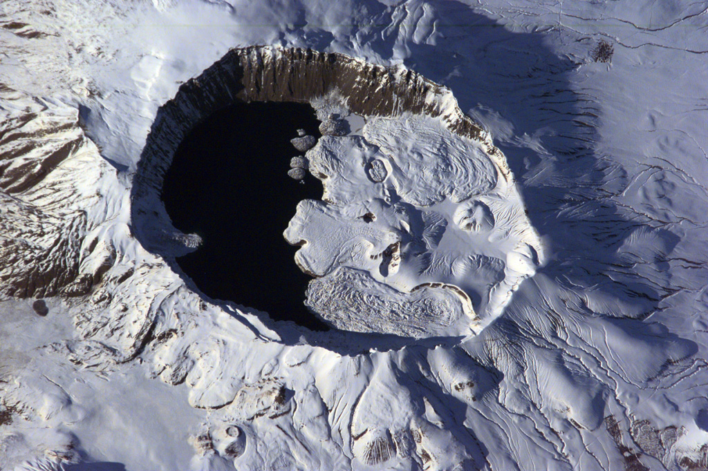 The summit of Nemrut Dagi is truncated by a 5 x 9 km caldera near Lake Van in eastern Turkey. A lake that partially fills the western side of the caldera is constrained by post-caldera eruptions that produced glassy obsidian lava flows from domes on the eastern caldera floor. A series of scoria cones and lava domes were erupted along N-S-trending fissures on the northern flank. Ash layers in Lake Van document numerous Holocene eruptions from Nemrut Dagi. NASA International Space Station image ISS001-E-6354, 2001 (http://eol.jsc.nasa.gov/).