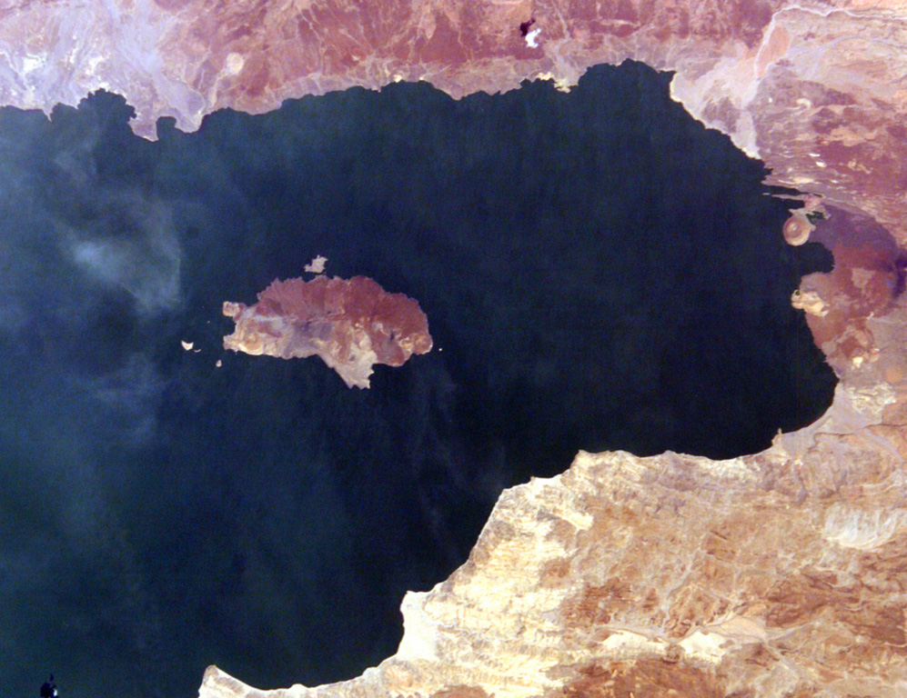 South Island (left center) is the southernmost and largest of the three volcanic islands in Lake Turkana. North is to the left in this International Space Station view. Lava flows erupted from a fissure extending the 11-km length of the island and form much of the eastern shoreline (top). An eruption from a scoria cone on South Island was witnessed during Count von Teliki's 1888 expedition. NASA International Space Station image ISS006-E-5095, 2002 (http://eol.jsc.nasa.gov/).