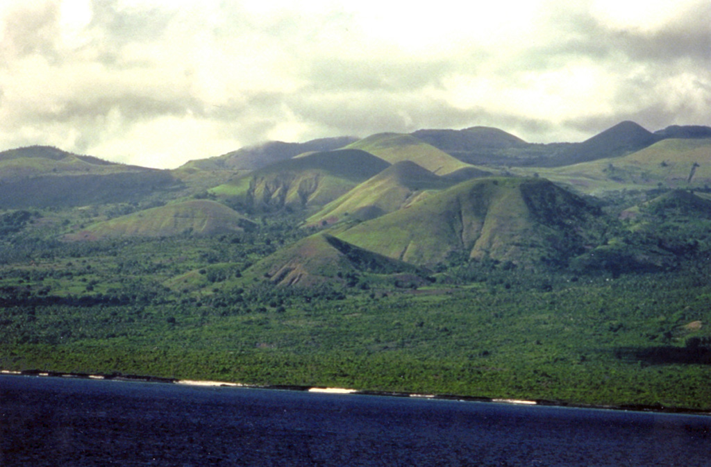 Cones can be seen here on the flanks of La Grille shield volcano at the N end of Grand Comore Island (also known as Ngazidja). It is located N of Karthala volcano, and the scoria cones reach up to 800 m in height. Recent lava flows, some perhaps as young as a few hundred years, have reached the sea from fissures on the lower W, N, and E flanks. Copyrighted photo by Stephen and Donna O'Meara, 2002.