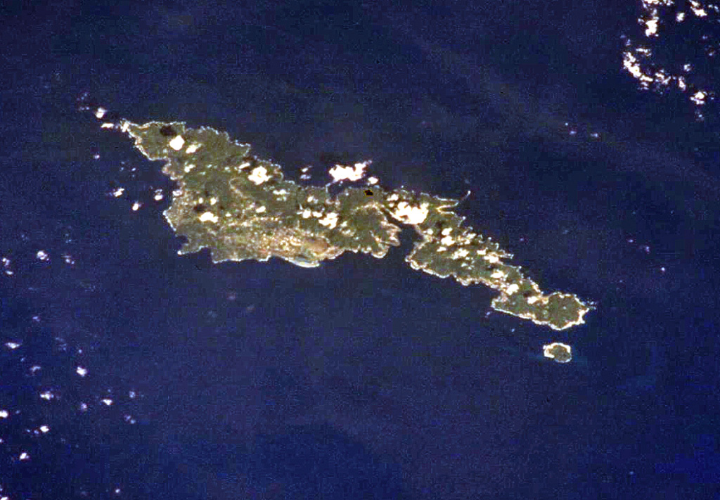 The elongated, 32-km-long island of Tutuila in the center of the Samoan Islands is seen in this International Space Station view (with north to the upper right). Five Pliocene-to-Pleistocene volcanoes were constructed along rift zones, and the Pago shield volcano in the center of the island was truncated by an eroded, 9-km-wide caldera that incorporates Pago Pago harbor (right-center). Following a lengthy period of erosion, the Leone tuff cones and cinder cones were erupted during the Holocene across the southernmost portion of the island (left-center). NASA International Space Station image ISS002-701-263, 2001 (http://eol.jsc.nasa.gov/).