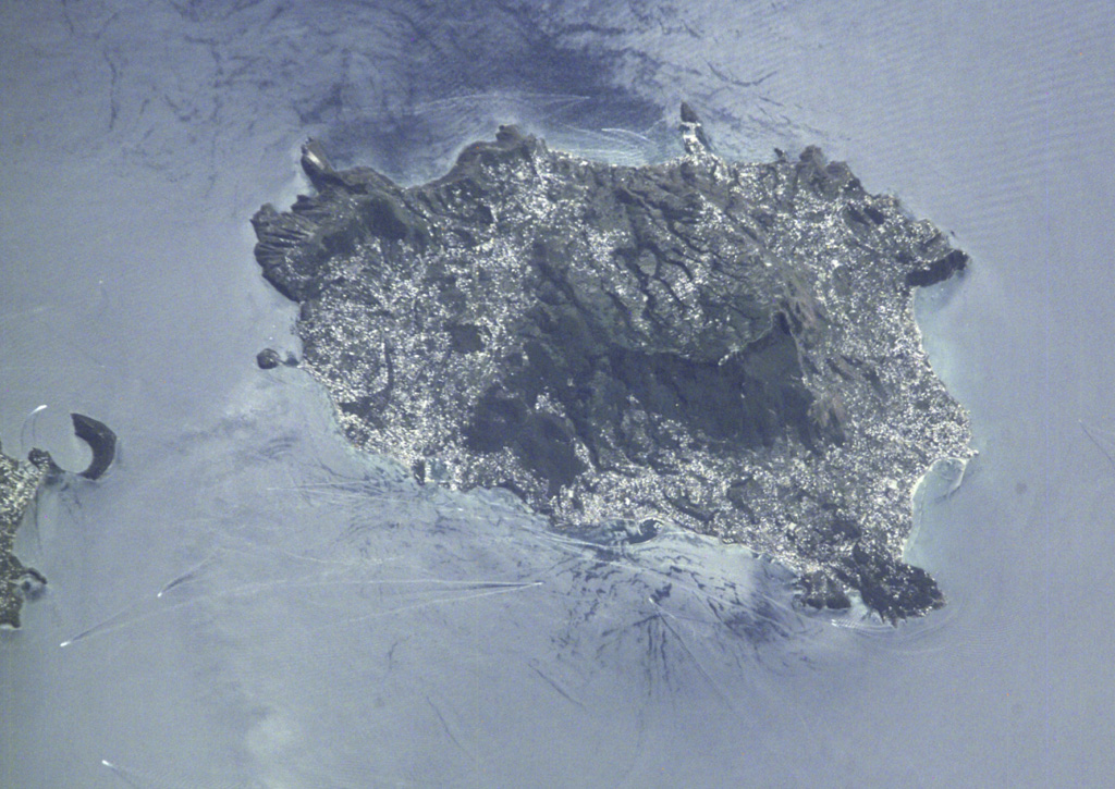 The Ischia volcanic complex forms a 6 x 9 km island W of the Bay of Naples seen in this International Space Station image. Tectonism has influenced volcanic activity at Ischia, and its high point (the dark-colored area in the center) is a horst (raised fault block) composed of ignimbrite deposits associated with Pleistocene caldera formation. During the Holocene, a series of pumiceous tephras, tuff rings, lava domes, and lava flows were erupted. NASA International Space Station image ISS002-E-8200, 2001 (http://eol.jsc.nasa.gov/).