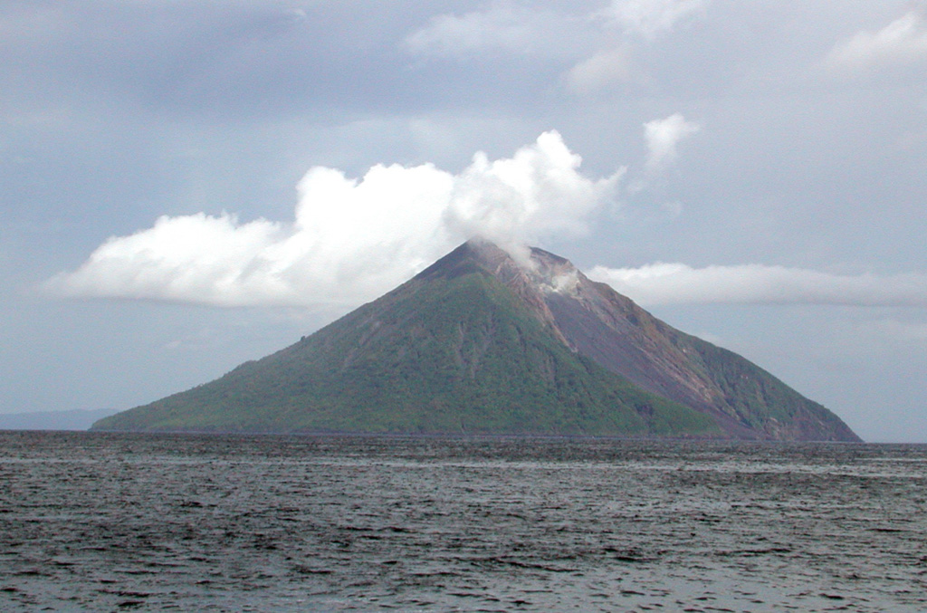 The northern side of the 3.5-km-wide Tinakula volcano at the NW end of the Santa Cruz Islands. The small island is the exposed portion of a stratovolcano that rises 3-4 km from the sea floor. A large breached crater extending from the summit to below the NW coast is visible to the right and has been the source of frequent eruptions dating back to at least 1595.  Photo by Donn Tolia, 2002 (Geological Survey of the Solomon Islands, courtesy of CSIRO).