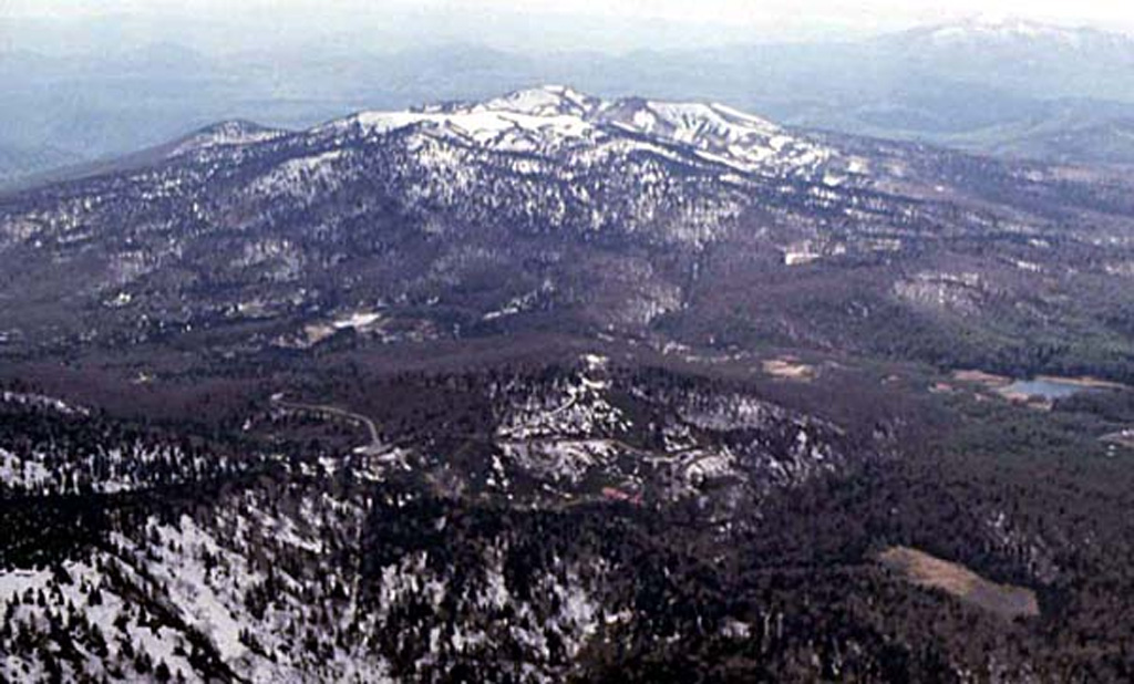 Akita-Yakeyama, seen here from the E, is one of several Japanese volcanoes named Yakeyama ("Burning Mountain"). Yakeyama contains a lava dome in its 600-m-wide summit crater and the flat-topped Kuroshimori lava dome is visible to the left. Several thermal areas are located on the lower western flank. Copyrighted photo by Hiroshi Yagi (Japanese Quaternary Volcanoes database, RIODB, http://riodb02.ibase.aist.go.jp/strata/VOL_JP/EN/index.htm and Geol Surv Japan, AIST, http://www.gsj.jp/).