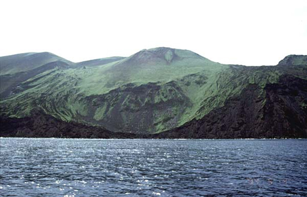 Oshima-Oshima volcano is seen here from the N with the Kanpodake cone (back-center) that formed during the 1741 eruption. Major edifice collapse that year produced a large scarp open to the north, with the walls visible at the sides of the image. The 4-km-wide island is 55 km W of the SW tip of Hokkaido, and is the emergent summit of two coalescing volcanoes: Higashiyama at the eastern end of the island, and Nishiyama at the western end. Copyrighted photo by Tomoyo Hayakawa (Japanese Quaternary Volcanoes database, RIODB, http://riodb02.ibase.aist.go.jp/strata/VOL_JP/EN/index.htm and Geol Surv Japan, AIST, http://www.gsj.jp/).