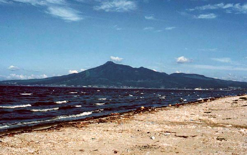 The SE side of Osorezan is seen here above Mutsu Bay is the Shimokita Peninsula in northernmost Honshu. It contains a 3-km-wide caldera partly occupied by a shallow lake that drains through the north caldera wall.  Copyrighted photo by Tadahide Ui (Japanese Quaternary Volcanoes database, RIODB, http://riodb02.ibase.aist.go.jp/strata/VOL_JP/EN/index.htm and Geol Surv Japan, AIST, http://www.gsj.jp/).