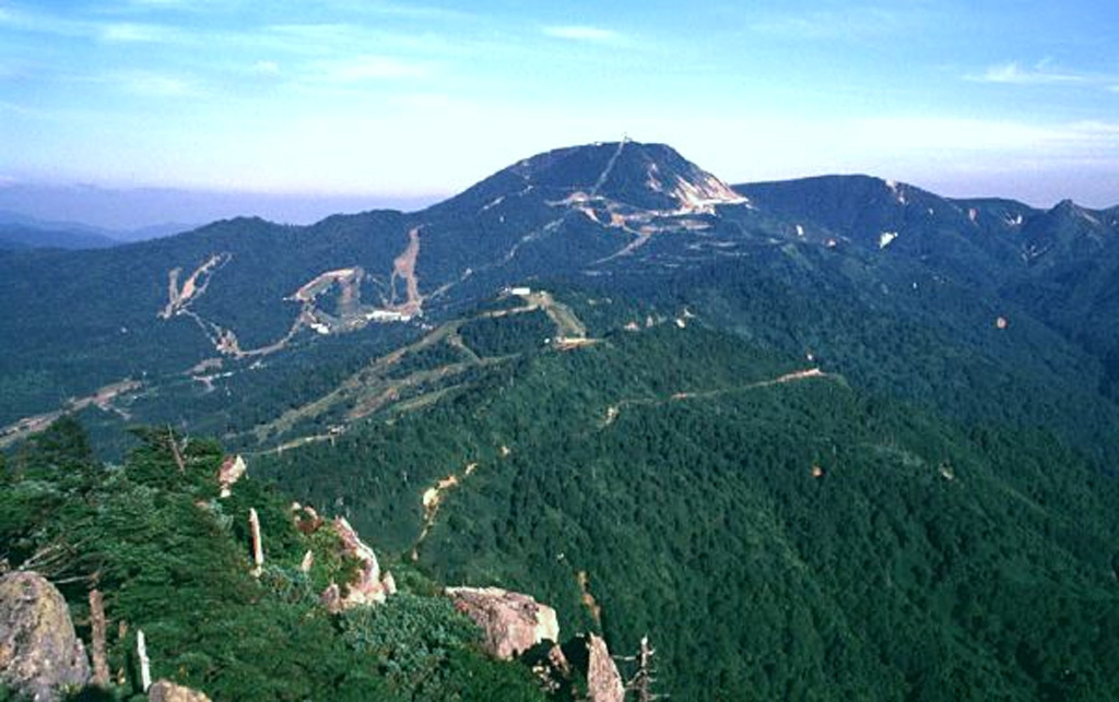 Yokoteyama volcano of the Shiga volcanic complex is seen from Kasagatake to its west. Ski trails are prominent in this summer view of the Shiga-Kogen (Shiga Plateau). The Shiga volcanic complex is located immediately N of Kusatsu-Shiranesan. Copyrighted photo by Shun Nakano (Japanese Quaternary Volcanoes database, RIODB, http://riodb02.ibase.aist.go.jp/strata/VOL_JP/EN/index.htm and Geol Surv Japan, AIST, http://www.gsj.jp/).