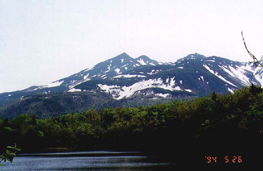 Shiretoko-Iozan is seen here in late spring from the Shiretoko-Goko on the W side of the volcano. It is located at the NE tip of Hokkaido on the Shiretoko Peninsula and is noted for the extrusion of molten sulfur during eruptions in 1889 and 1936. Two large craters at the summit open to the NW. Copyrighted photo by Yasuo Ikeda, 1994 (Japanese Quaternary Volcanoes database, RIODB, http://riodb02.ibase.aist.go.jp/strata/VOL_JP/EN/index.htm and Geol Surv Japan, AIST, http://www.gsj.jp/).