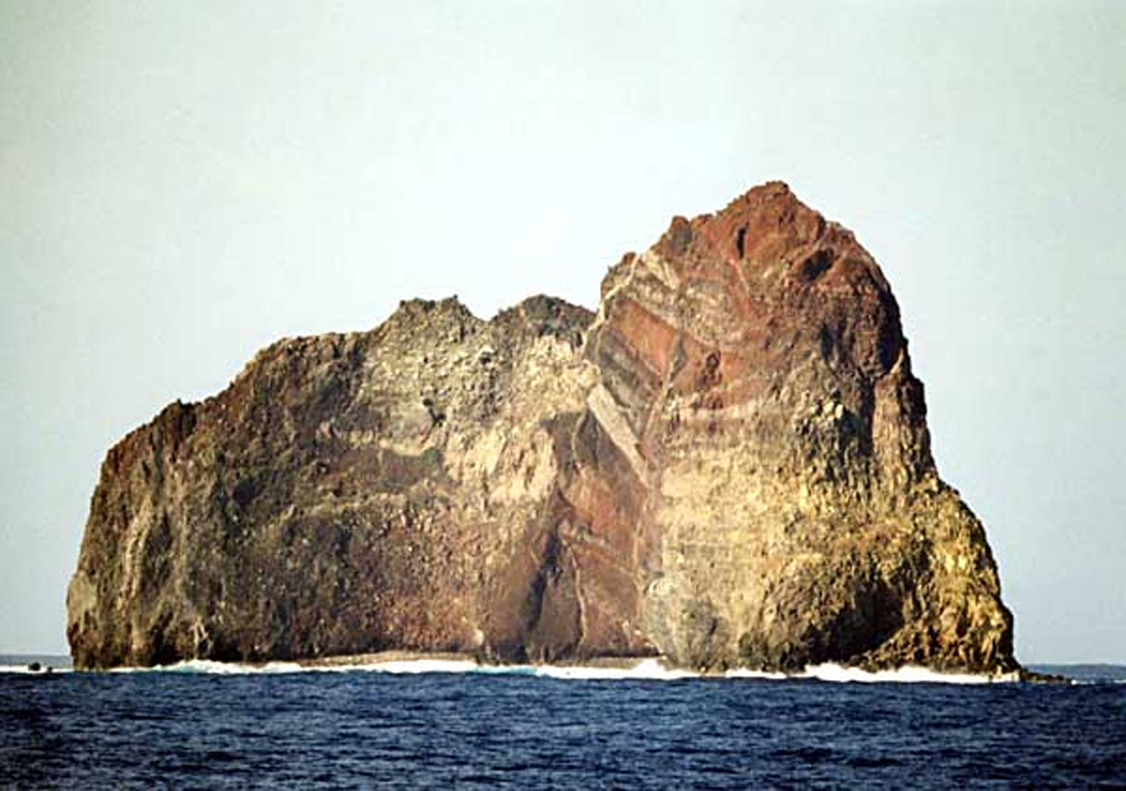 Wave erosion has exposed the spectacular stratigraphy of Sumisujima, a steep-sided pinnacle that is a remnant of the outer southern flank of a submarine caldera 6-9 km wide. Intrusive rocks, dikes, tephra layers, and breccias are visible in this view of the eastern side of the pinnacle. Submarine eruptions have been reported from a number of locations near here, the last of which occurred in 1916. Water discoloration has been frequently observed nearby since the 1970s. Copyrighted photo by Kenichiro Tani, 2002 (Japanese Quaternary Volcanoes database, RIODB, http://riodb02.ibase.aist.go.jp/strata/VOL_JP/EN/index.htm and Geol Surv Japan, AIST, http://www.gsj.jp/).