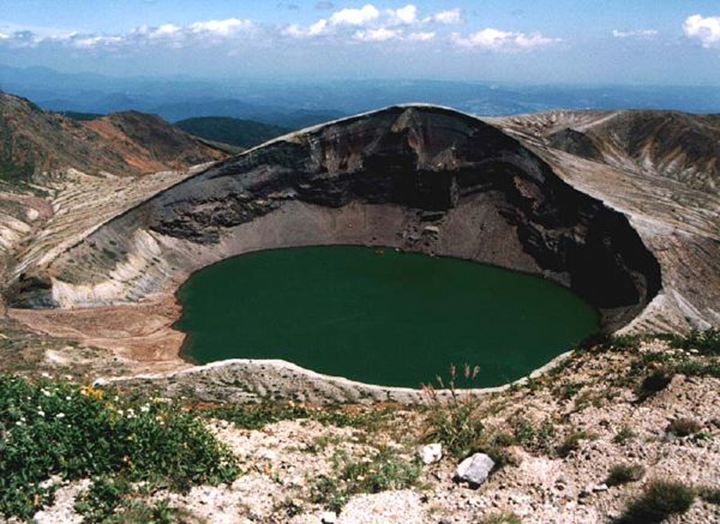 Okama crater of Goryudake within the Zaozan volcanic complex is shown here from the E. The 360-m-wide lake is about 60 m deep and is the site of many recorded eruptions. White mud deposited on the lake floor is periodically disturbed by gas emission, changing the color of the water. Copyrighted photo by Yoshihisa Kawanabe (Japanese Quaternary Volcanoes database, RIODB, http://riodb02.ibase.aist.go.jp/strata/VOL_JP/EN/index.htm and Geol Surv Japan, AIST, http://www.gsj.jp/).