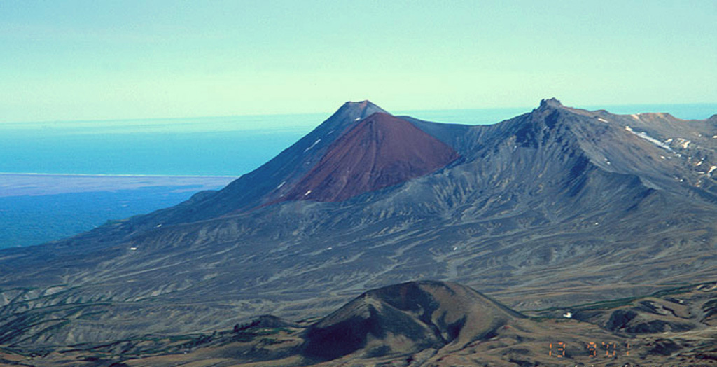 Three Holocene cones of Kikhpinych are seen in this view from the west with the Pacific Ocean in the background. The distinct brown feature in the center is the Krab lava dome that grew on the E flank of Savich (back center), the youngest cone of the complex at about 1,400 years old. The peak at right is the mid-Holocene Zapadny cone. In the foreground is the Duga cone, which erupted about 3,200 years ago and produced lava flows up to 10 km long. Copyrighted photo by Vera Ponomareva (Holocene Kamchataka volcanoes; http://www.kscnet.ru/ivs/volcanoes/holocene/main/main.htm).