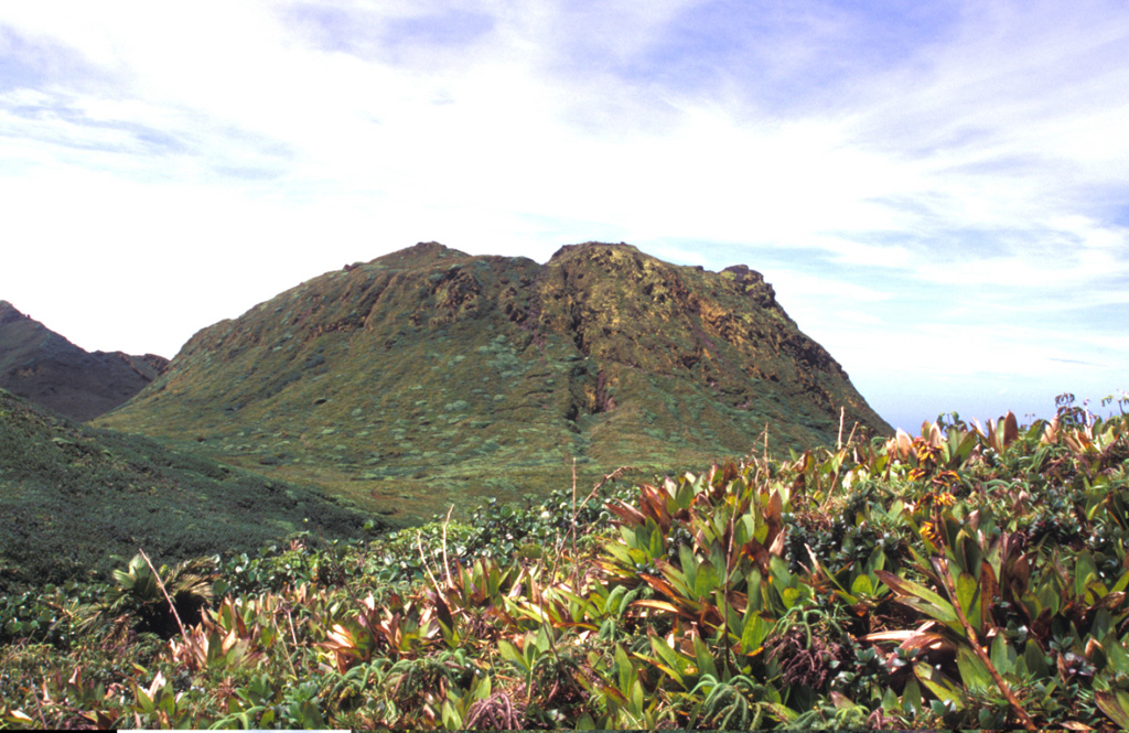 La Soufrière lava dome, forming the summit of Soufrière Guadeloupe volcano, was emplaced at the end of a major eruption that took place around the mid-15th century.  The eruption began with collapse of part of a previous lava dome forming a debris avalanche, followed by a major explosive eruption in which dacitic pumice and andesitic banded scoria were sequentially ejected.  The eruption concluded with growth of La Soufrière summit lava dome, which is seen here from the north. Photo by Paul Kimberly, 2002 (Smithsonian Institution).