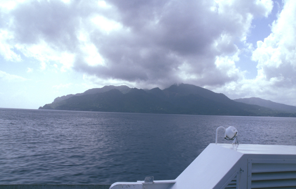 The NW side of Morne aux Diables volcano at the northern tip of Dominica is seen from the hydrofoil ferry between Guadeloupe and Dominica.  Lava domes are prominent on the 681-m-high volcano, both at the summit and its flanks.  Bathymetry reveals evidence for a twin-peaked lava dome about 5 km off the NW coast that reaches to within 153 m of the sea surface.  Both domes, known informally as Twin Peaks, rise more than 1000 m above the sea floor. Photo by Paul Kimberly, 2002 (Smithsonian Institution).