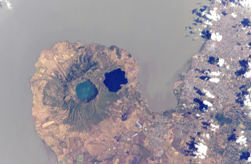 Two lake-filled calderas dominate the 11-km-wide Chiltepe Peninsula extending NE-ward into Lake Managua.  Greenish Lake Apoyeque was the source of two major late-Pleistocene plinian pumice deposits, and dark-blue Lake Jiloa (Xiloa) produced the Jiloa Pumice about 6500 years ago.  The two calderas cut the summit of the Chiltepe pyroclastic shield volcano.  Nicaragua's capital city Managua, extending across much of the right side of the image, has been subjected to major tectonic earthquakes.  NASA International Space Station image ISS004-E-5765, 2002 (http://eol.jsc.nasa.gov/).