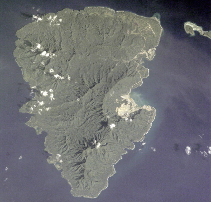 The 20-km-long Lihir Island is a complex of several overlapping Pliocene-to-Holocene volcanoes N of Latangai Island, the youngest of which is Luise volcano. Luise Harbor (right center) lies within a 5.5-km-wide caldera that is breached on the NE side. Thermal activity includes boiling hot springs, mud pools, and sulfur-encrusted low-temperature fumaroles. NASA Space Shuttle image STS001-5933, 2001 (http://eol.jsc.nasa.gov/).