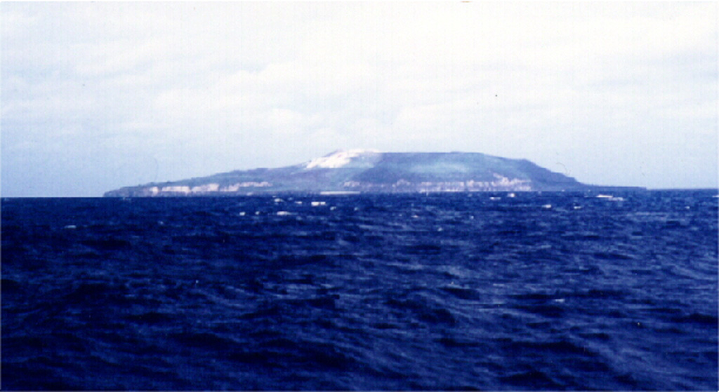 Seen from the NE, Fonualei volcano is a small, less than 2-km-wide island that contains active fumaroles in the crater, which is breached to the SW with a fresh lava flow extending to the sea and forming a rugged shoreline. Blocky lava flows from a central cone have reached the sea through notches in the caldera rim. Eruptions have been recorded since 1791. Photo by Paul Taylor (published in Taylor and Ewart, 1997).