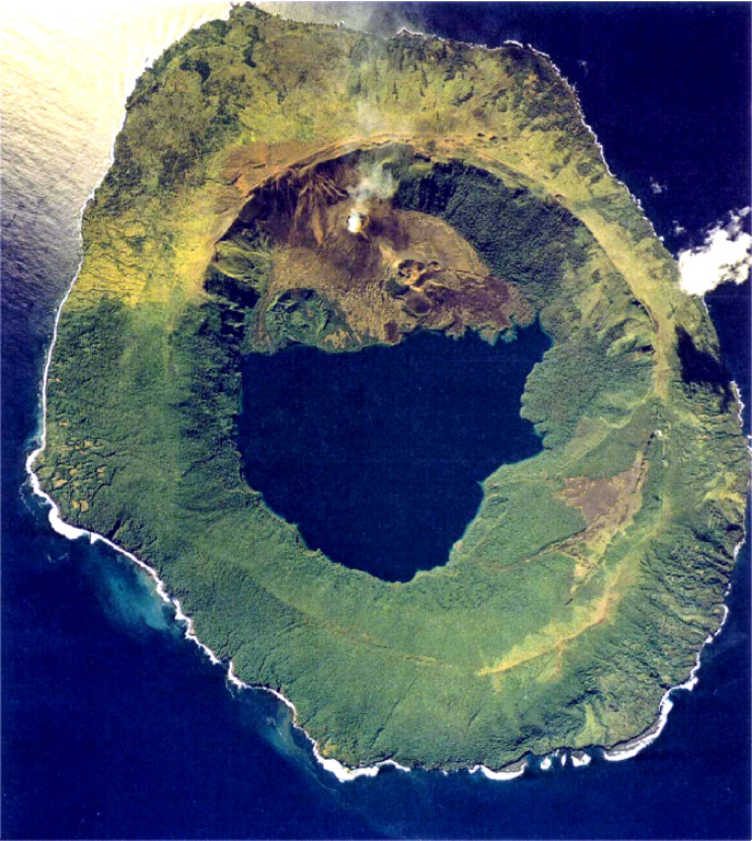 A small plume rises from Lofia cone on the N side of the caldera lake of Tofua volcano in this 1990 aerial photograph. Recent tephra was emplaced onto the caldera rim to the NW. The steep walls of the 5-km-wide caldera are about 500 m high. Three post-caldera cones were constructed at the N end of a cold fresh-water caldera lake, whose surface lies only 30 m above sea level.  Aerial photo by Tonga Ministry of Lands, Survey, and Natural Resources, 1990 (published in Taylor and Ewart, 1997).