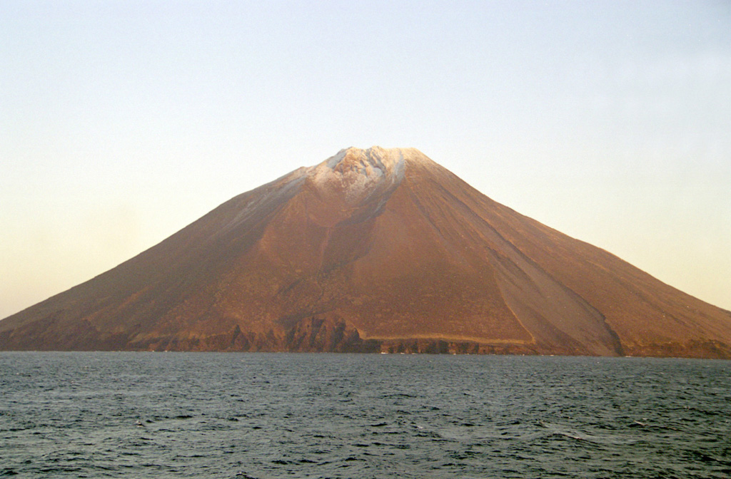 Etorofu-Atosanupuri forms a peninsula on the SW side of Iturup Island, seen here from the SW. A 2-km-wide caldera was subsequently infilled by a cone that forms the present summit. Strombolian eruptions have been prevalent and eruptions were recorded during 1812 and 1932. Photo by Alexander Rybin, 2001 (Institute of Marine Geology and Geophysics, Yuzhno-Sakhalin).