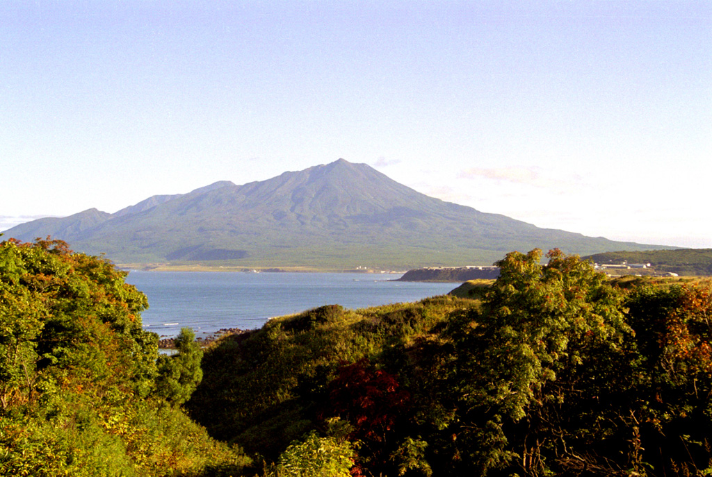 The Chirippusan Peninsula protrudes NW into the Sea of Okhotsk from central Iturup Island and is composed of two Holocene cones. Minamichirippusan (center) lies at the southern end of the peninsula and Chirippusan (in the background to the left) forms the northern end. Lava flows from Minamichirippusan reach the coast on both the E and W sides of the peninsula. Photo by Alexander Rybin, 2001 (Institute of Marine Geology and Geophysics, Yuzhno-Sakhalin).