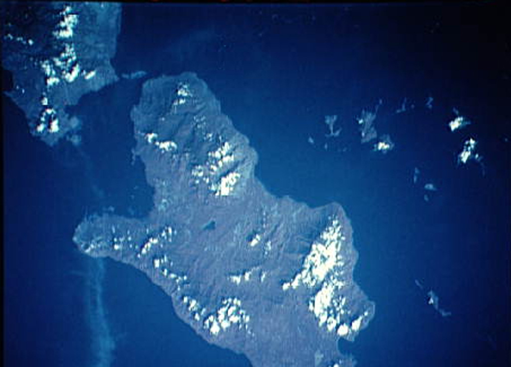 Late Cenozoic volcanic rocks cover much of the Kukuia Peninsula (left center) on the SW side of Fergusson Island and areas north of the peninsula. The Iamalele-Fagululu area, located north of the peninsula and south of the Mailolo metamorphic block forming the NW tip of the island, contains a series of lava domes and lava flows and abundant hot springs and fumaroles. Eight small lava domes are located near Fagululu village and around Salt Lake. Young volcanic rocks are also present on Goodenough Island (upper left). NASA Space Shuttle image STS44-83-80, 1991 (http://eol.jsc.nasa.gov/).
