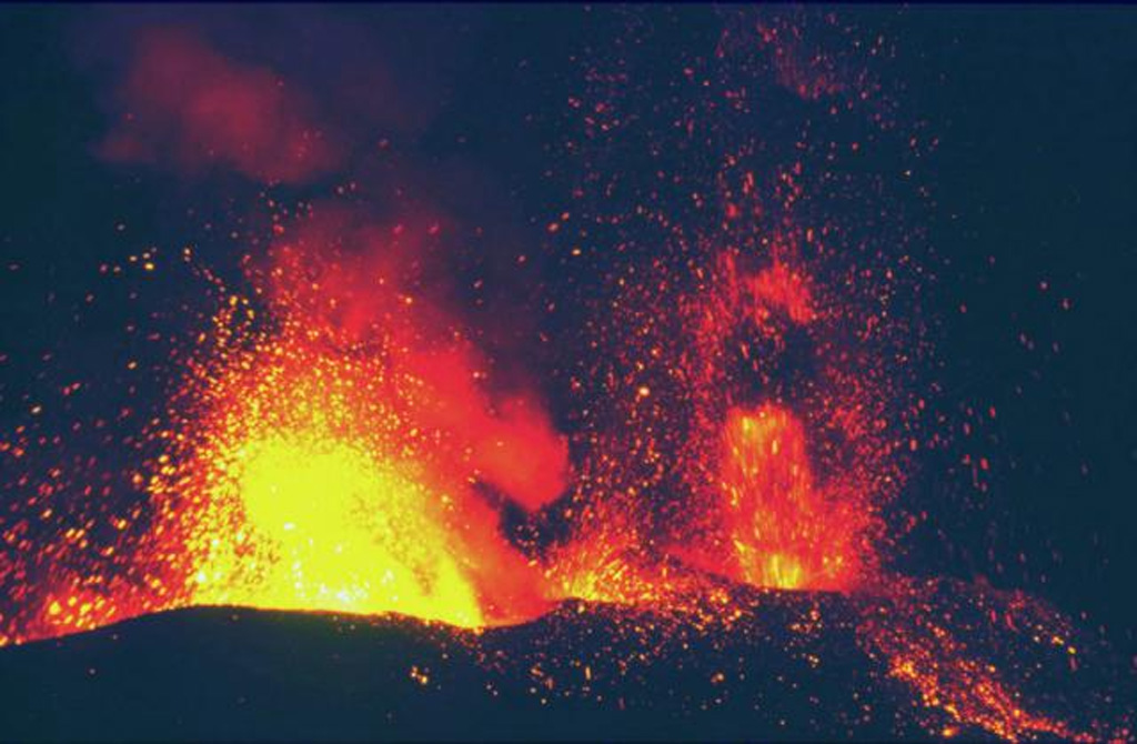 An eruption at Etna on 30 October 2002 shows incandescent lava fountains and associated spatter. The photo was taken from Mt. Ponte di Ferro looking E. This was part of an eruption that began on 26 October. Lava fountaining began on 27 October from fissure vents on the N and S flanks. Photo by Jean-Claude Tanguy, 2002 (University of Paris).