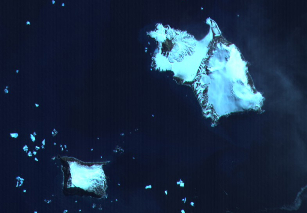 The southern end of Candlemas Island (upper right) consists of an eroded, glacier-covered stratovolcano whose lava flows may have originated from a former summit vent located east of the island.  The snow-free area at the NW part of the island is Lucifer Hill, a scoria-cone complex that was the source of snow-covered lava flows seen in this image.  Geysers and hot pools have been observed on several occasions during the 20th century.  Vindication Island (lower left), of possible Holocene age, is located 4.5 km west of Candlemas Island.   ASTER satellite image, 2001 (National Aeronautical and Space Administration, courtesy of ASTER science team).