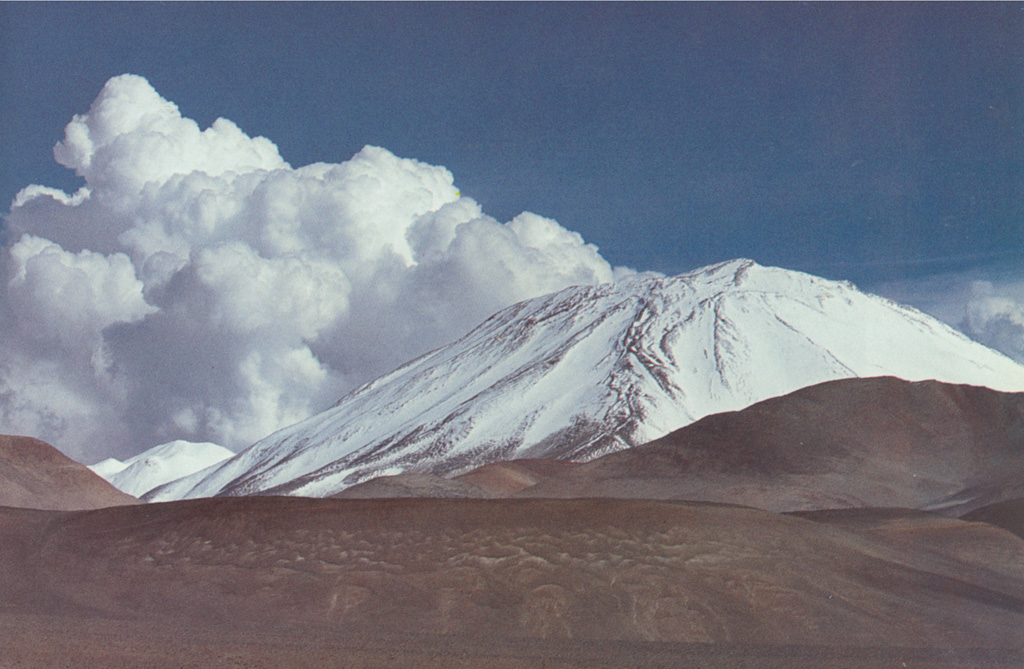 Snow and ice drapes the western flank of Nevado Incahuasi along the Chile/Argentina border, as seen from Paso las Lozas at 5100 m.  Nevado de Incahuasi is a complex volcanic massif located ENE of Nevados Ojos del Salado volcano.  Two stratovolcanoes occupy a compound 3.5 -km-wide caldera.  Pleistocene lava domes are located on the west and SW flanks of the 6621-m-high Nevado de Incahuasi, one of the world's highest volcanoes.   Photo by Oscar González-Ferrán (University of Chile).