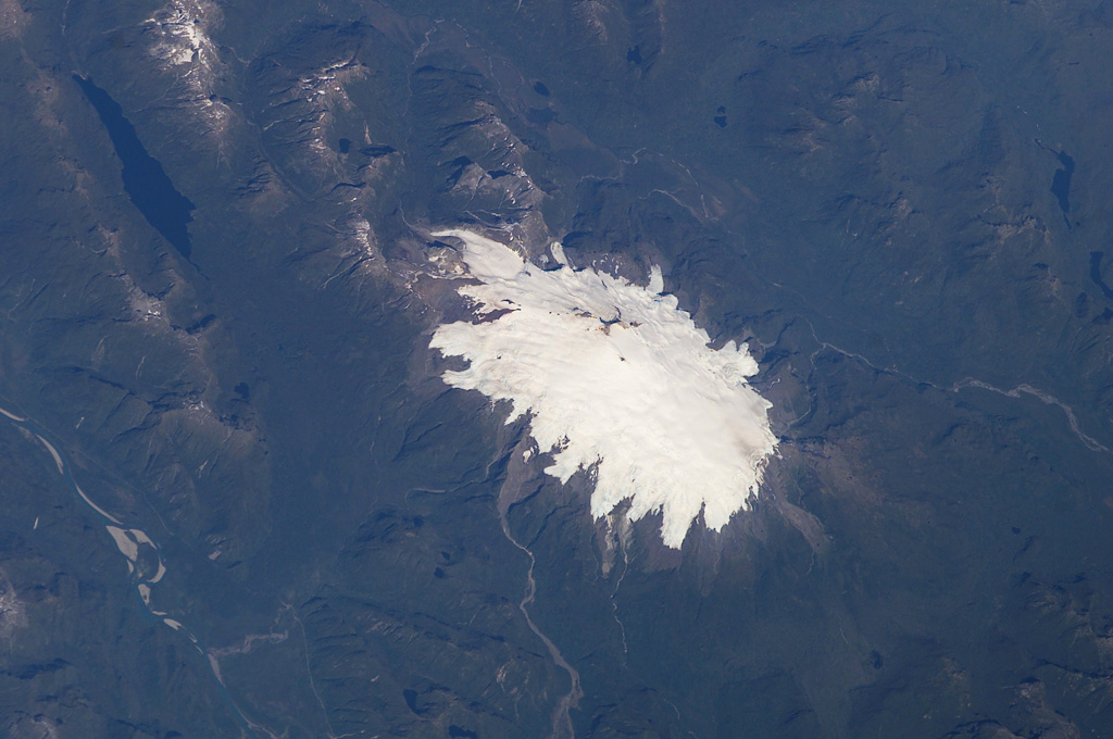 The glacier-clad Melimoyu stratovolcano dominates this NASA International Space Station image (with north to the lower left). The 8-km-wide, largely buried ice-filled caldera is drained by a glacier through a notch in the NE rim.  The 2400-m-high basaltic-andesite volcano is of Pleistocene to possible Holocene age and has several cinder cones.    NASA International Space Station image ISS006-E-42125, 2003 (http://eol.jsc.nasa.gov/).