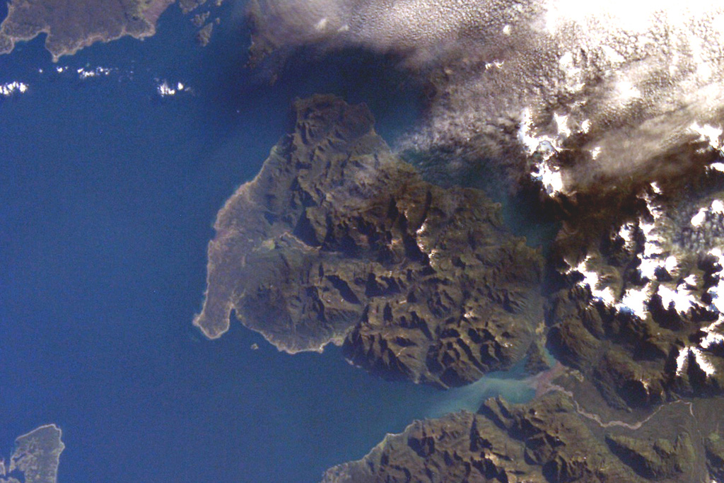 The roughly 20-km-wide Huequi Peninsula extends about 40 km into the Gulf of Ancud in southern Chile.  Volcán Huequi is a small, glacier-free volcano located just to the right of the center of this NASA International Space Station image (with north to the upper left).  A parasitic cone is located on the west side of the 1318-m-high basaltic-andesite volcano, which has an 800-m-wide crater.  Explosive eruptions were recorded during the 19th and 20th centuries, initially in 1890 and most recently in about 1920.       NASA International Space Station image ISS008-E-12502, 2004 (http://eol.jsc.nasa.gov/).
