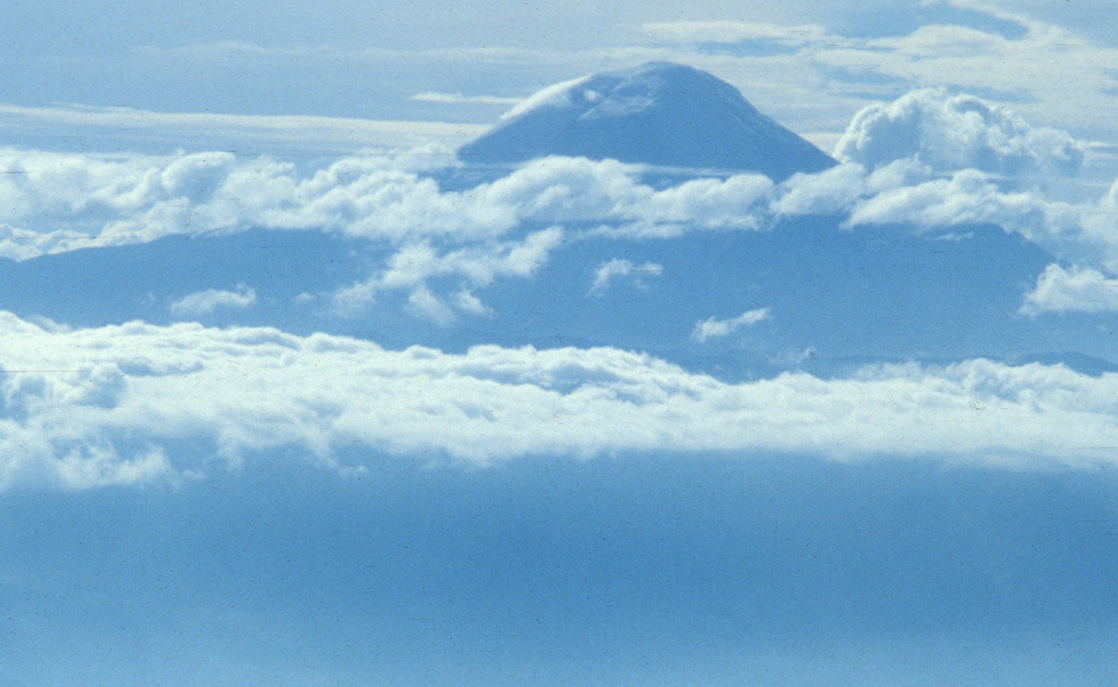 Clouds drape glacier-clad, 6310-m-high Chimborazo, Ecuador's highest volcano.  Chimborazo anchors the southern end of the country's "Avenue of Volcanoes" 30 km NW of the city of Riobamba.  The volcano is mostly of Pliocene-to-Pleistocene age, but recent work has shown that it remained active into the Holocene.  The volcano is composed of three edifices along an east-west line, the youngest and westernmost of which forms the current summit of Chimborazo.   Photo by Lee Siebert, 1978 (Smithsonian Insitution).