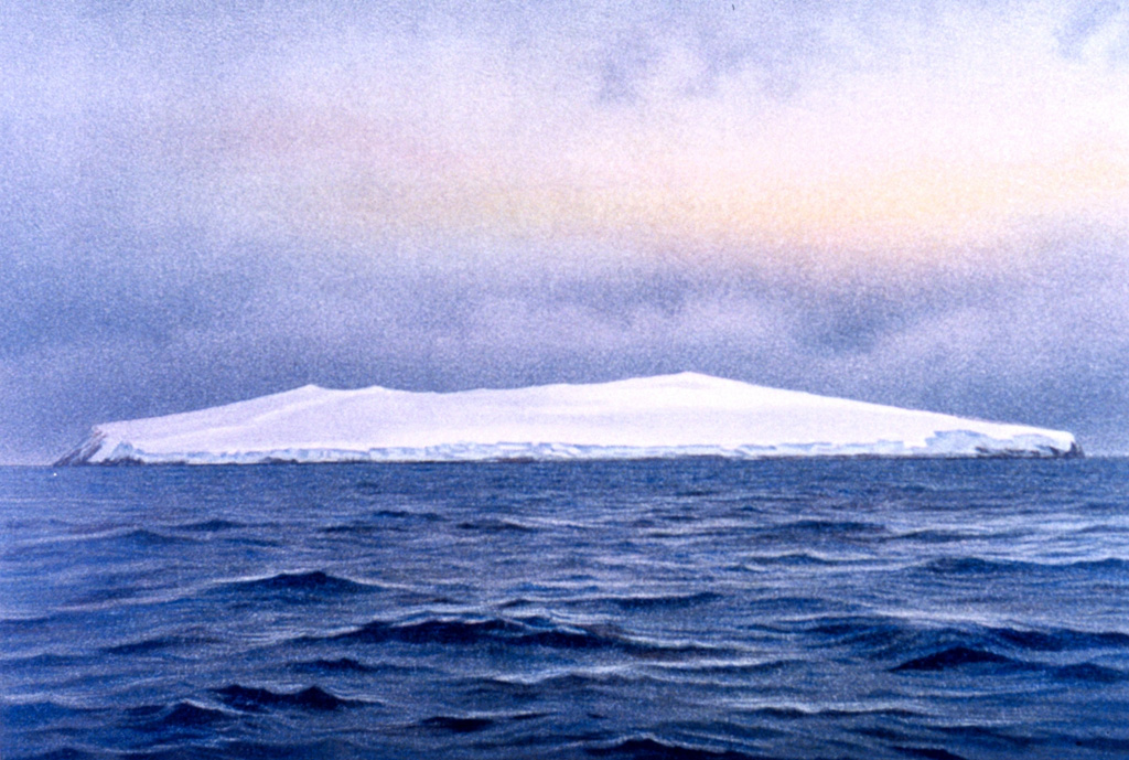 The uninhabited shield volcano of Bouvet Island is depicted from the SE in this 26 November  1898 watercolor painting. About 95% of the 10-km-wide island is glaciated, and sampling on this basaltic-to-rhyolitic volcano has been restricted to coastal cliffs. A caldera on the opposite (NW) side of the island is breached to the sea. Bouvet, also referred to as Bouvetoya, is located just off the Southwest Indian Ridge, east of the triple junction between the African, South American, and Antarctic plates.  Watercolor painting by F. Winter, 1898 (In: Chun, 1903; courtesy of NOAA Photo Library).