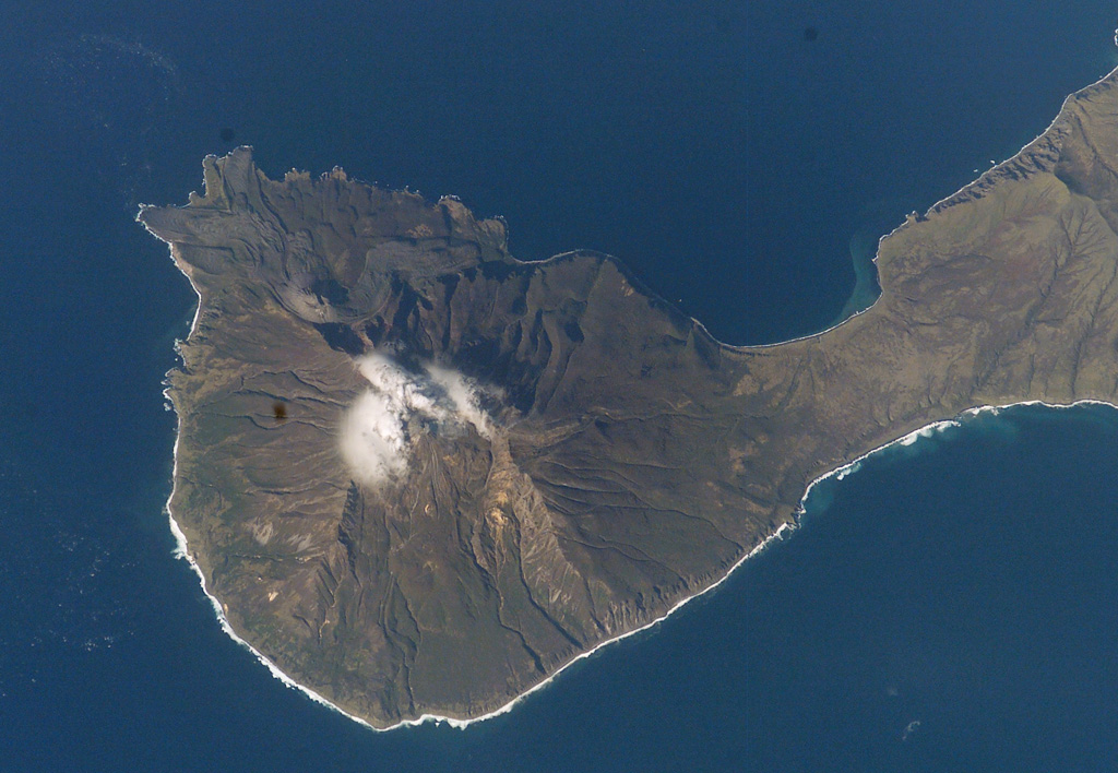 Goriaschaia Sopka dome and the Milne cone are shown here on the SW end of Simushir Island. Milne is the larger snow-capped peak and Goriaschaia Sopka is on the NW flank within a large open crater. The dome has produced lava flows that form the irregular shoreline to the N, some of which are visible in this NASA Space Shuttle image. NASA Space Shuttle image STS112-E-5671, 2002 (http://eol.jsc.nasa.gov/).