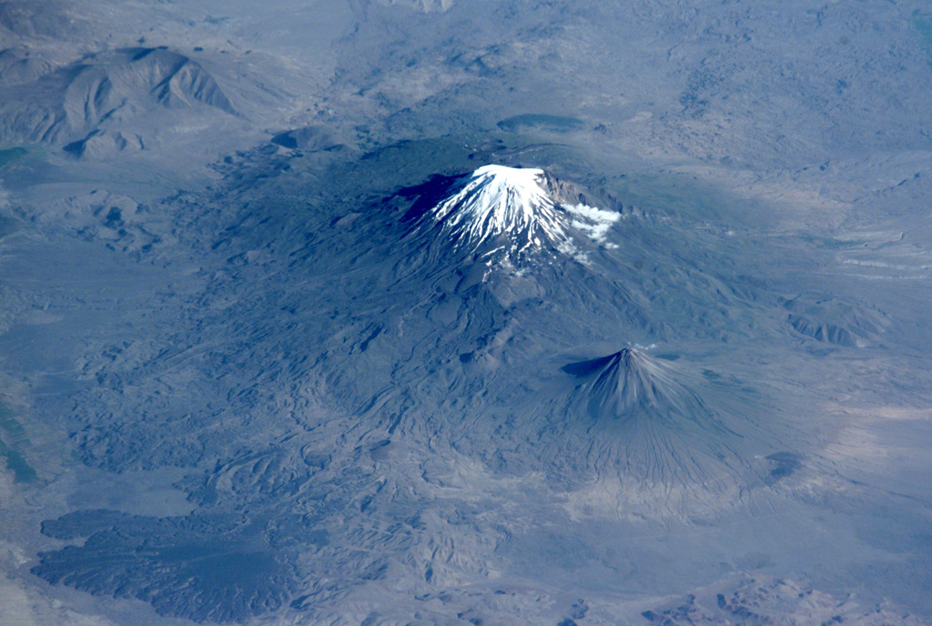 Glacier-clad Mount Ararat, seen in this NASA International Space Station image, is Turkey's highest, largest volume, and easternmost volcano. Kucuk Ararat (or Lesser Ararat) lies across a saddle to the SE (right-center). Prominent lava flows with flow levees were erupted from flank vents between Greater and Lesser Ararat; one of these terminates in a fan-shaped lobe at the lower left. Pyroclastic-flow deposits from Ararat overlie early Bronze Age artifacts. NASA International Space Station image ISS002-E-10032, 2001 (http://eol.jsc.nasa.gov/).