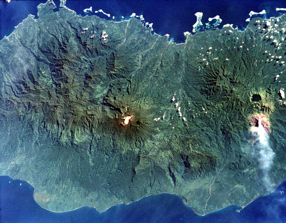 Tore volcano is in the Emperor Range on NW Bougainville Island. The Tore massif lies to the left of Balbi volcano, which is the light-colored area at the center of the image. Two Pleistocene ignimbrites from Tore formed a broad fan that extends the coastline to the W (lower left). The dark-colored caldera lake of Billy Mitchell volcano is at the right, above a plume originating from Bagana volcano. N is to the upper left of this NASA image. NASA International Space Station image ISS001-358-32, 2001 (http://eol.jsc.nasa.gov/).
