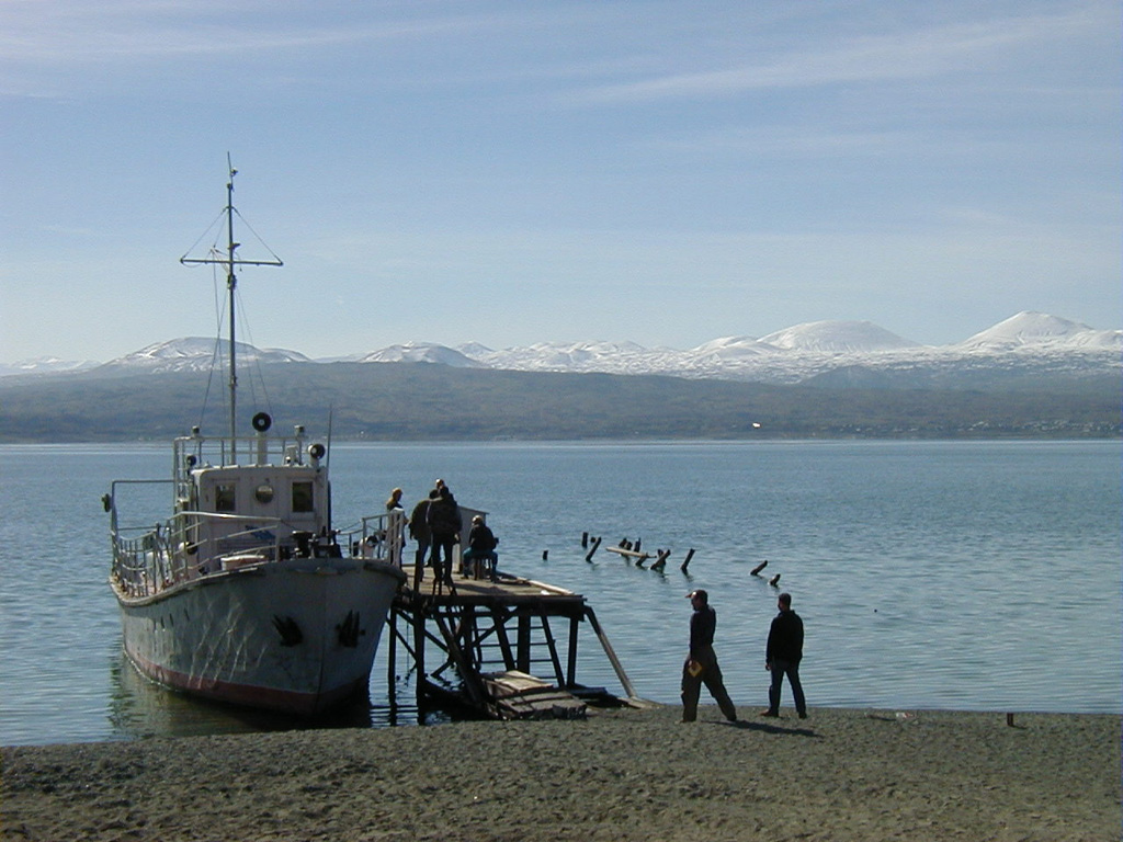 The snow-capped cones of the Ghegam Ridge volcanic field rise across Lake Sevan from a fishing village on its NE shore. This volcanic field in west-central Armenia covers a 35-km-wide area between the capital city of Yerevan and Lake Sevan. Morphologically youthful lava flows from the central and eastern portions of Ghegam Ridge flowed into Lake Sevan. Photo by Ivan Savov, 2002 (Smithsonian Institution).