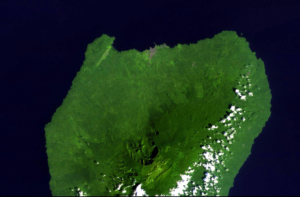 Santa Isabel volcano occupies the northern end of Bioko (Fernando Poo) Island in this NASA Landsat view with north to the upper left. A large escarpment cuts the northern side of the 3,007-m-high volcano, whose summit is cut by regional NE-SW-trending faults. Numerous scoria cones are present, many of which lie along the same tectonic trend. Santa Isabel is the only Bioko Island volcano with reported historical eruptions, although they are poorly documented. The brown area along the northern coast is the capital city of Malabo. NASA Landsat image, 1999 (courtesy of Hawaii Synergy Project, Univ. of Hawaii Institute of Geophysics & Planetology).