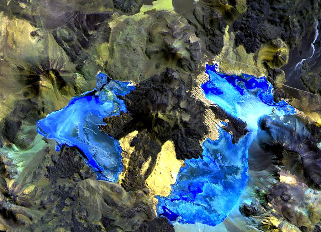 Caichinque volcano forms a topographic high dividing lakes of Salar Capur (left) from Salar Talar (right).  More than a half dozen vents produced andesitic-to-dacitic lava flows, with young flows descending to the NE and SE from the 4450-m-high summit.  One prominent flow traveled 6 km to the east, forming two lobes extending into the Salar Talar.  Other youthful looking flows traveled to the west, forming lobes extending into Salar Capur, and SSW, dividing the two salars.   NASA Landsat image, 1999 (courtesy of Hawaii Synergy Project, Univ. of Hawaii Institute of Geophysics & Planetology).