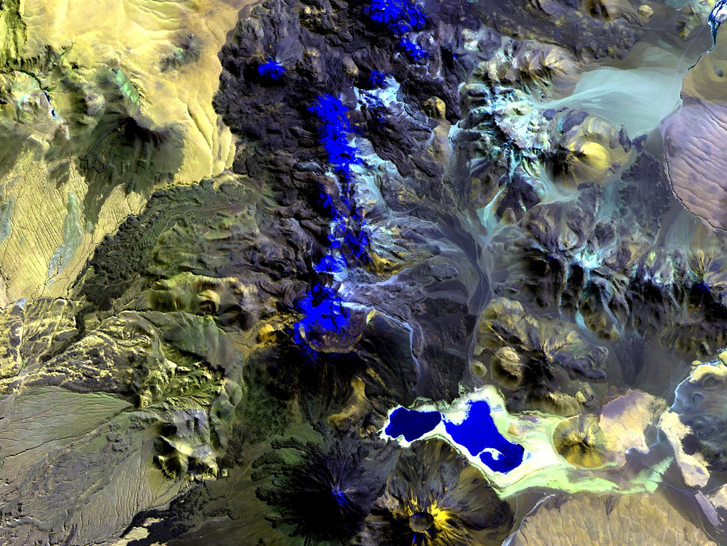 The N-S-trending chain of andesitic-dacitic volcanoes along the Chile-Bolivia border just left of the center of this Landsat image is the Sairecábur-Escalante volcanic massif.  Snow-covered areas are blue in this image of the chain, which contains at least 10 postglacial centers.  A massive lava flow extends to the west, and a youthful flow traveled SE from Curinquinca volcano at the NE side of the chain.  Laguna Verde is the left-hand lake at the bottom, NE of dark-colored Licancabur volcano; Juriques volcano to its right has a pronounced summit crater. NASA Landsat image, 1999 (courtesy of Hawaii Synergy Project, Univ. of Hawaii Institute of Geophysics & Planetology).