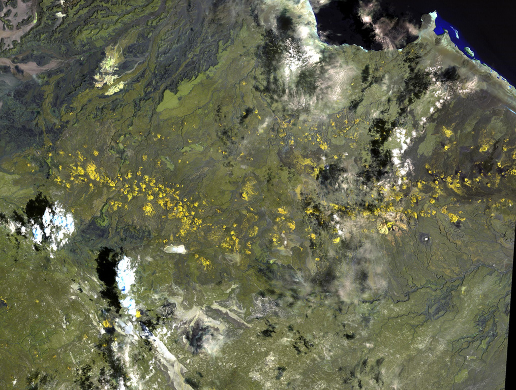 The long chain of pyroclastic cones and lava flows extending E-W across this Landsat image is the Assab volcanic field near the Red Sea coast in southern Eritrea. This spectacular range of basaltic cinder cones and associated lava flows covers a 55 x 90 km area, and flows reached the Red Sea along a broad front. The vents were constructed along a broad E-W-trending line that extends to the coastal city of Assab, out of view to right. NASA Landsat image, 1999 (courtesy of Hawaii Synergy Project, Univ. of Hawaii Institute of Geophysics & Planetology).