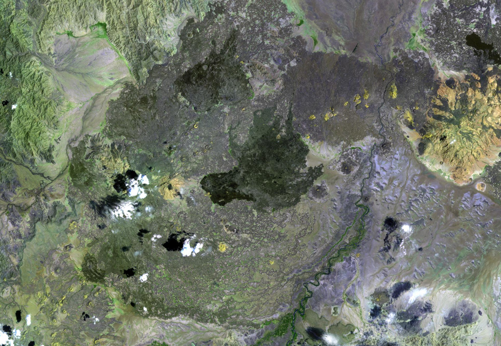 Dabbayra (center), the westernmost volcano of the Afar depression, lies near the edge of the Ethiopian escarpment. In contrast to structural trends in other parts of Afar, Dabbayra (also known as Bar-Ali) consists of a basaltic shield volcano elongated in an ENE-WSW direction. The only silicic volcanic rocks are a NNW-trending line of lava domes and lava flows near the crest of the volcano NASA Landsat image, 1999 (courtesy of Hawaii Synergy Project, Univ. of Hawaii Institute of Geophysics & Planetology).